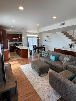 a living room with a couch and a table and a kitchen at Cozy North Park Townhome in San Diego