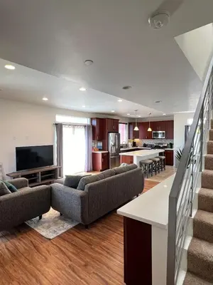 a large living room with couches and a kitchen at Cozy North Park Townhome in San Diego