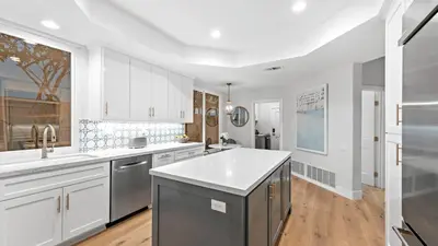a kitchen with white cabinets and a white counter top at Backyard Oasis w Fire Table Walk to Salt Creek Beach Dana Point Dreams in Dana Point
