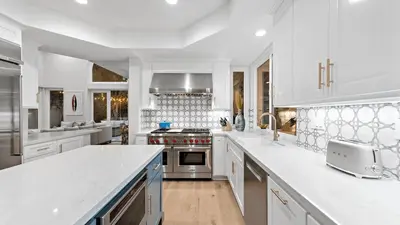 a kitchen with white cabinets and a stove top oven at Backyard Oasis w Fire Table Walk to Salt Creek Beach Dana Point Dreams in Dana Point