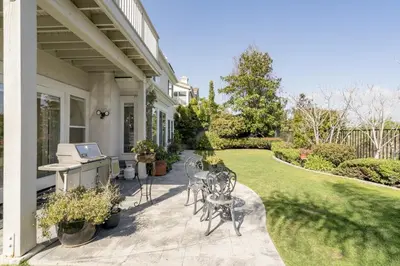 a patio with chairs and a table on a house at Luxe Family Villa ,116 inch Theater, Yard , Near Beaches in San Diego