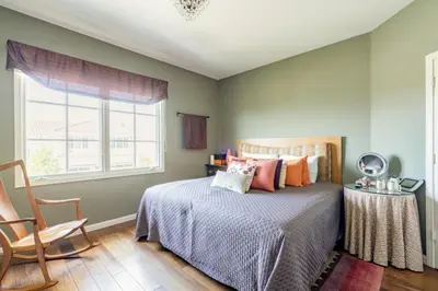 a bedroom with a bed and a chair and a window at Luxe Family Villa ,116 inch Theater, Yard , Near Beaches in San Diego