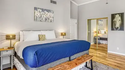 a bedroom with a large bed with a blue blanket at Temecula Wine Country Home w Pool Hot Tub Game Room Vineyard Views in Country Road Estates