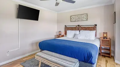 a bedroom with a large bed with a blue blanket at Temecula Wine Country Home w Pool Hot Tub Game Room Vineyard Views in Country Road Estates