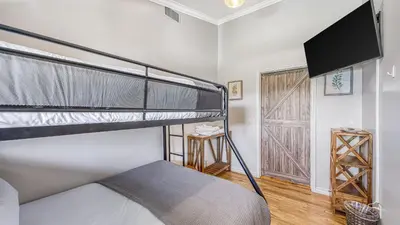 a bedroom with two bunk beds and a flat screen tv at Temecula Wine Country Home w Pool Hot Tub Game Room Vineyard Views in Country Road Estates