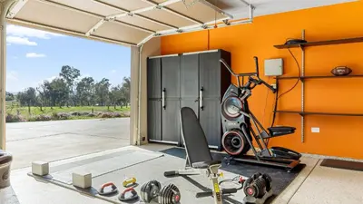 an orange room with a gym with a bike at Temecula Wine Country Home w Pool Hot Tub Game Room Vineyard Views in Country Road Estates