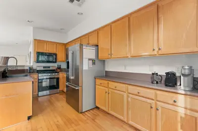 a kitchen with wooden cabinets and a stainless steel refrigerator at Sweet Serenity 3 bed with community pool, spa in Encinitas