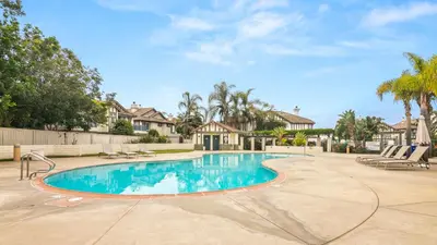 a swimming pool in a yard with chairs and trees at Sweet Serenity 3 bed with community pool, spa in Encinitas