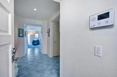 a hallway with a tv on a white wall at Nomad's Oceanfront Retreat 2B2B Condo in Oceanside