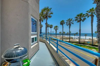a view of the beach from the balcony of a building at Nomad's Oceanfront Retreat 2B2B Condo in Oceanside