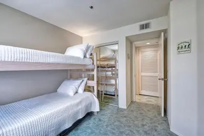a room with two bunk beds and a hallway at Nomad's Oceanfront Retreat 2B2B Condo in Oceanside