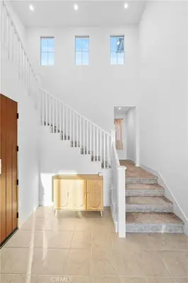 a staircase with a wooden cabinet in the middle of a room at Hidden Gem New 4B3B House UCI Disney Amazing view in Irvine