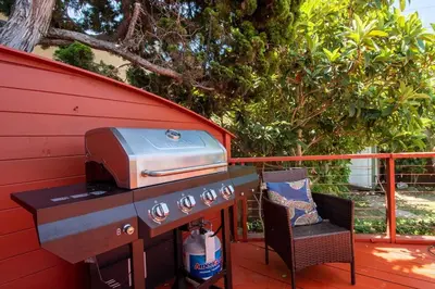 a grill and a chair sitting on a deck at Ultimate Escape! Huge Yard Parking Walk to Beach in San Diego