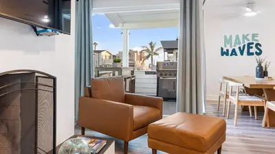 a living room with a chair and a table and a kitchen at Steps from the SandBoardwalk Outdoor Dining Parking and Patio in Newport in Newport Beach