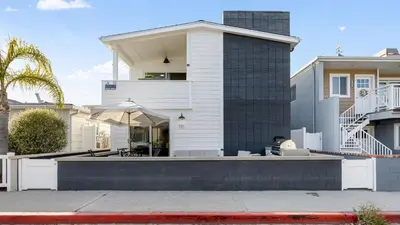 a white house with a patio in front of it at Steps from the SandBoardwalk Outdoor Dining Parking and Patio in Newport in Newport Beach