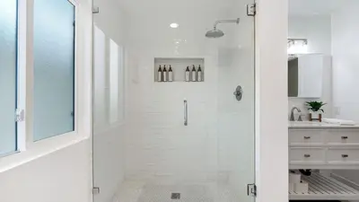 a white bathroom with a shower and a sink at Steps from the SandBoardwalk Outdoor Dining Parking and Patio in Newport in Newport Beach