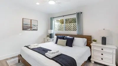 a bedroom with a bed with two towels on it at Coastal-Chic Newport Stay Steps to the Beach Dining Boardwalk Optional Add-On Unit in Newport Beach