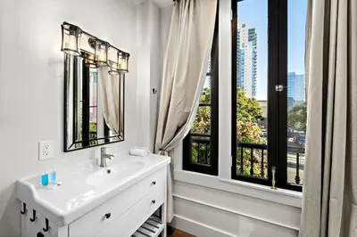 a white bathroom with a sink and a window at The Artifact Hotel in San Diego