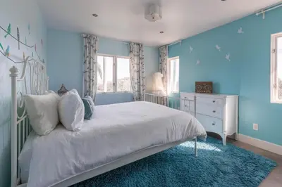 a bedroom with a white bed and a blue wall at Scenic View Estate with Pool & Hot Tub in San Diego