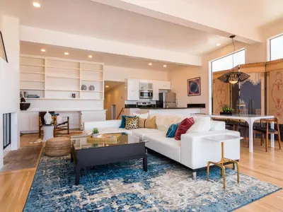 a living room with a white couch and a table at La Jolla Condo Oceanview, Zen and Coastal Charm in San Diego