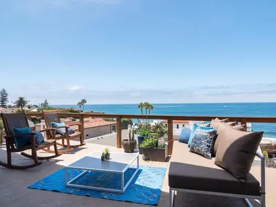 a patio with a couch and a table and the ocean at La Jolla Condo Oceanview, Zen and Coastal Charm in San Diego