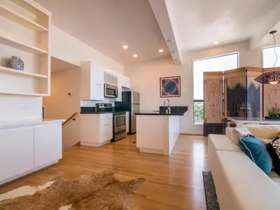 a living room with a couch and a kitchen at La Jolla Condo Oceanview, Zen and Coastal Charm in San Diego