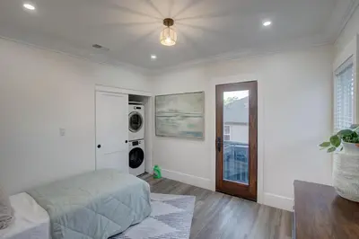a bedroom with a bed and a washer and dryer at Historic Barrio Logan Bungalow in San Diego