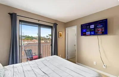 a bedroom with a bed and a window with a balcony at Hidden Gem 3Bed 3Ba Retreat Jacuzzi AC Balconies in San Diego