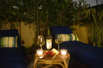 a table with glasses and a bottle of wine and candles at Charming Cottage with Parking, Bikes, Walk to Sand in San Diego