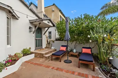 two chairs sitting on a patio in front of a house at Charming Cottage with Parking, Bikes, Walk to Sand in San Diego