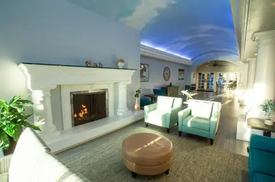 a living room with a fireplace and blue chairs at Tamarack Beach Hotel in Carlsbad