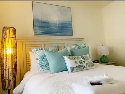 a bedroom with a bed with blue and white pillows at Sunset Cliffs Oceanfront Oasis, San Diego - Stunning Views & Ocean Sounds in San Diego