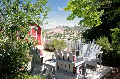 two wooden chairs sitting on a patio with a fence at Pet Friendly Breathtaking Cottage with Great Views and Hot-tub in Rainbow, California in Fallbrook