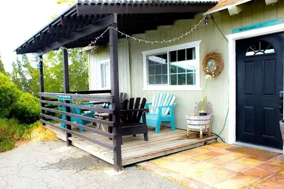 a porch of a house with a black door at Pet Friendly Fantastic Cottage with Hot-tub in Rainbow, California in Fallbrook