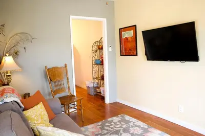 a living room with a couch and a flat screen tv on the wall at Pet Friendly Fantastic Cottage with Hot-tub in Rainbow, California in Fallbrook