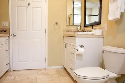 a bathroom with a toilet and a sink and a mirror at Pet Friendly Fantastic Cottage with Hot-tub in Rainbow, California in Fallbrook