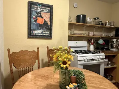 a kitchen with a table with flowers and a picture on the wall at Pet Friendly Fantastic Cottage with Hot-tub in Rainbow, California in Fallbrook