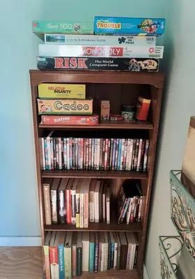a book shelf filled with lots of books at Pet Friendly Breathtaking Cottage with Hot-tub in Rainbow, California in Fallbrook