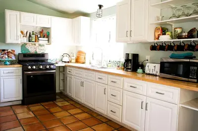 a kitchen with white cabinets and a black appliance at Pet Friendly Fantastic Secluded Cottage with Hot-tub in Rainbow, California in Fallbrook