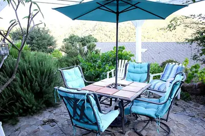 a table and chairs with an umbrella on a patio at Pet Friendly Fantastic Secluded Cottage with Hot-tub in Rainbow, California in Fallbrook