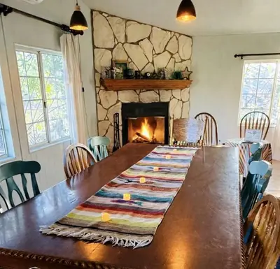a dining room with a table and a fireplace at Pet Friendly Fantastic Secluded Cottage with Hot-tub in Rainbow, California in Fallbrook