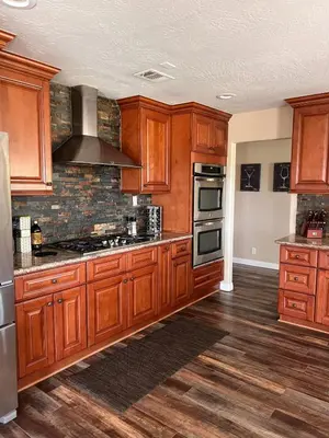a kitchen with wooden cabinets and a stove top oven at Temecula Wine Country Villa in Temecula