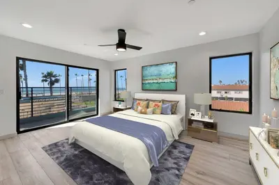 a bedroom with a large bed and large windows at Steps to the Beach in Imperial Beach