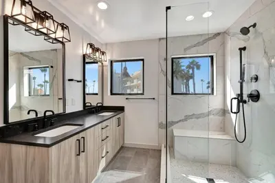 a bathroom with a shower and two sinks and a shower stall at Steps to the Beach in Imperial Beach