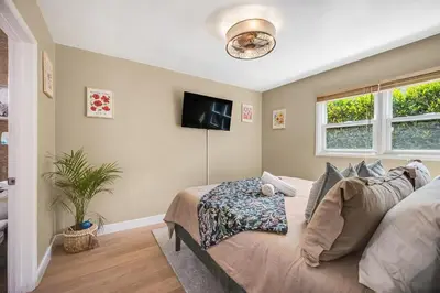 a bedroom with a bed and a flat screen tv at 1BD Heart of PB Pet Friendly Private Sanctuary in San Diego
