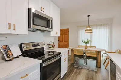 a kitchen with white cabinets and a black stove top oven at Immaculate Home near Balboa Park, SD Zoo, & Cafés in San Diego