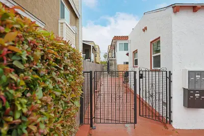 a gate in front of a building with a hedge at Immaculate Home near Balboa Park, SD Zoo, & Cafés in San Diego