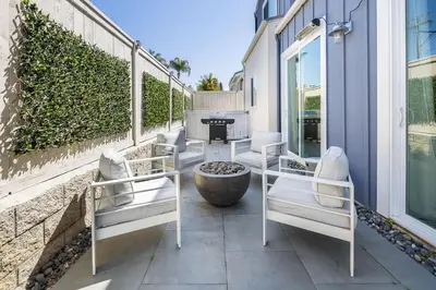 a patio with white chairs and a table at Large 4 Bedroom Close To Beach in Encinitas