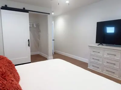 a bedroom with a bed and a flat screen tv at Lime Light La Mesa New 4BR 3BA Group Friendly in La Mesa