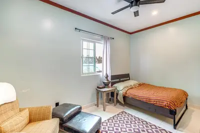 a bedroom with a bed and a couch and a window at Game Room and Fire Pit Quiet Family Home in Bonita in Bonita